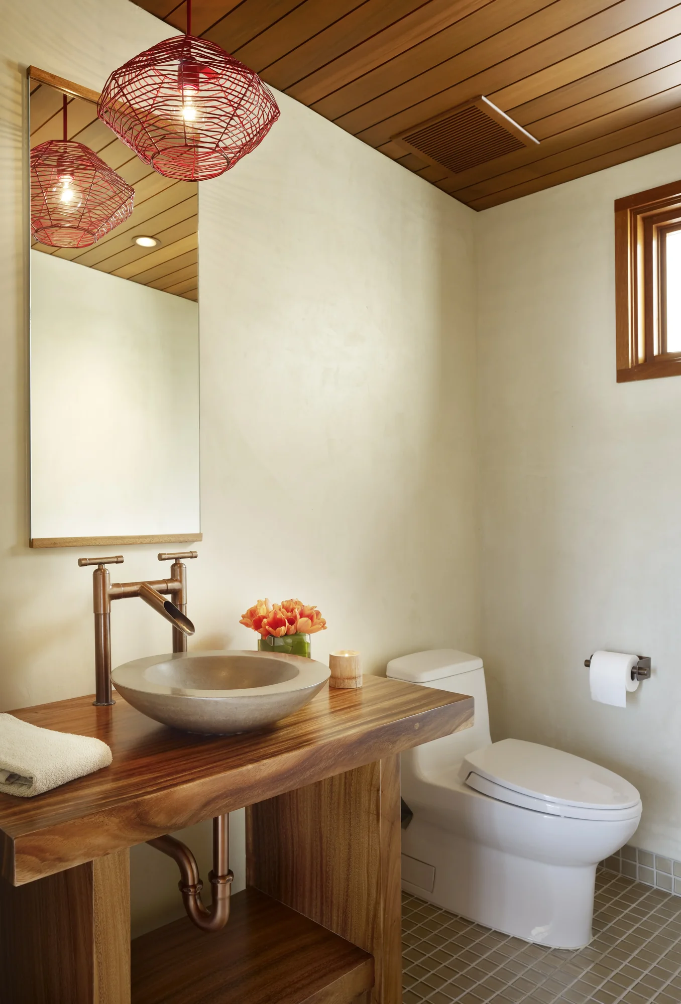 Modern powder room featuring wood ceiling, vessel sink on live-edge vanity, and red wire pendant lights